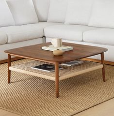 a living room with a couch, coffee table and rug on the floor in front of it