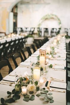 a long table is set with candles and flowers for an elegant wedding reception or special event