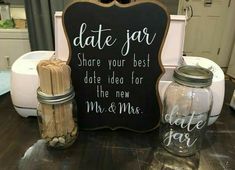 a couple of jars sitting on top of a table next to a chalkboard sign