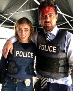 two people dressed as police officers posing for the camera with blood smeared on their face