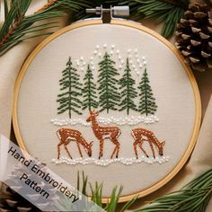 a cross stitch pattern with deer and pine trees