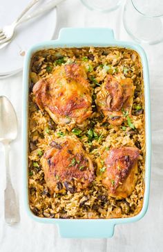 chicken and rice casserole in a blue dish with silverware on the side