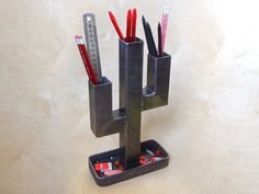 a metal holder with pencils and rulers in it