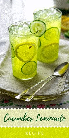 two glasses filled with lemonade and limes sitting on a table next to some limes