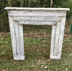 an old white fireplace surround in the grass