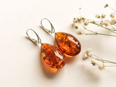 Massive natural Baltic amber cognac color earrings is a perfect choice for classy style admirers! Perfect choice to brighten up office outfit or look even more beautiful on a special occasion! Shaped in drop form these earrings are the best example of royal and unforgettable jewelry. MATERIALS AND SIZE: Stone: 100% Natural Baltic Amber Findings: sterling silver 925 Weight: ± 8 g  (0,28 oz)                                                     Bead size: ± 2,8 cm (1,1 in) x 1,8 cm (0,7 in) Total le Elegant Orange Earrings For Formal Occasions, Elegant Amber Teardrop Earrings, Brown Teardrop Earrings For Formal Occasions, Elegant Baltic Amber Teardrop Jewelry, Formal Brown Teardrop Earrings, Classic Orange Earrings For Formal Occasions, Elegant Teardrop Baltic Amber Jewelry, Classic Amber Earrings For Formal Occasions, Elegant Handmade Amber Earrings