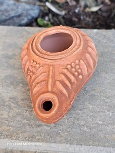 a brown vase sitting on top of a stone slab