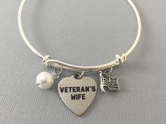 Do you love someone who is in the military or who was in the military? Are you in the military and want to give your wife a special gift? This beautiful Veteran's Wife bracelet is beautiful and it has three charms on it - a charm that says Veteran's Wife, a pearl, and an American flag. Adjustable bracelet is silver plated.  Charms are made from a zinc alloy metal which is lead and nickel free.  Your purchase will arrive in a cute gift box ready to give as a gift or special present for yourself. Military Bracelet, Marine Wife, Military Gift, Military Marines, Navy Wife, Navy Veteran, Army Wife, Love Someone, Military Wife