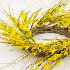 a wreath with yellow flowers and twigs on a white background, ready to be used as an ornament