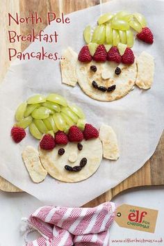 a plate with some fruit on it and a face made out of crackers next to other food items