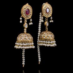 Perfect for luxurious formal festivities! The look includes a pair of earrings and a maang teekah. The beautiful jhumkey earrings are adorned with kundan stones, lab-created gemstones and faux pearl moti. The classic maang teekah is designed with gutka kundan and pearl moti hangings. Approximate earrings length is 3". Gold-plated on high-quality brass as base metal. Made by order. Kindly allow 4-6 weeks for the delivery of this item. For custom or urgent requests, please contact support@alacoutu Kundan Jhumkas With Gota Work For Reception, Kundan Jhumkas With Stone Work For Reception, Kundan Jhumkas With Latkans For Reception, Ceremonial Kundan Jhumkas With Stone Work, Ceremonial Kundan Jhumkas With Latkans, Kundan Danglers For Ceremonial Festive Occasions, Festive Kundan Danglers For Ceremonial Occasions, Kundan Jhumkas For Eid Reception, Mirror Work Jhumkas For Diwali Reception