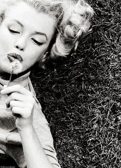 a black and white photo of a woman laying on the ground with her eyes closed