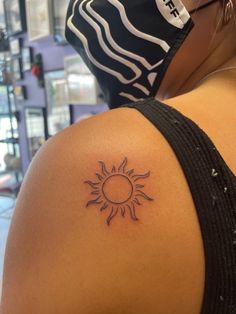 a woman with a sun tattoo on her shoulder