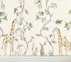 two giraffes are standing in front of a wall mural