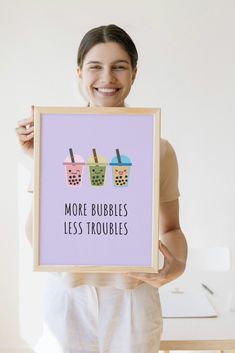 a woman holding up a framed poster with two ice creams and drinks on it