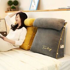 a woman sitting on a bed holding a tablet