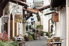 an alley way with tables and chairs lined up