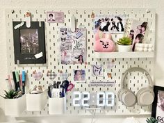 a white shelf topped with pictures and headphones on top of a wall covered in magnets