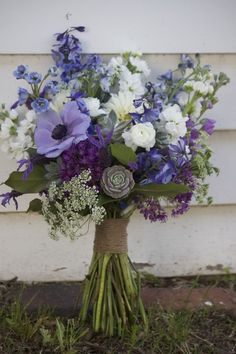 a bouquet of purple and white flowers on the ground