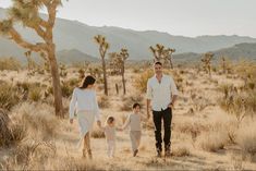 a man and two children walking through the desert with joshua trees in the foreground