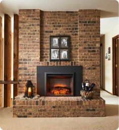 a fire place in the middle of a living room with pictures on the wall above it