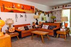 a living room filled with orange couches and wooden tables next to a large window