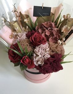 a flower arrangement in a pink box on a white surface with the name laghiya flowers