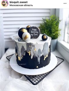 a black and white cake with gold decorations on it's side sitting on a table