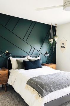 a bedroom with a bed, nightstands and green accent wall in the corner area