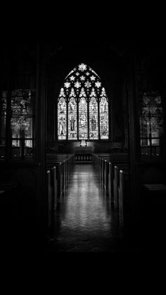 an empty church with stained glass windows and pews in the foreground at night