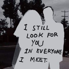 a man and woman standing next to each other holding a sign that says i still look for you in everyone i meet