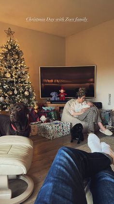 a woman sitting on a couch in front of a christmas tree with her feet up