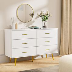 a white dresser with yellow legs and a round mirror