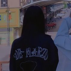 the back of a person wearing a black jacket that says de marzo