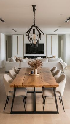 a dining room table with chairs and a television in the background