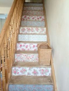 a set of stairs with floral carpet and basket on the bottom one handrails