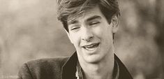 a black and white photo of a young man smiling