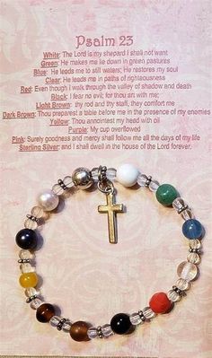 a bracelet with a cross and seven chakras on it, in front of a card