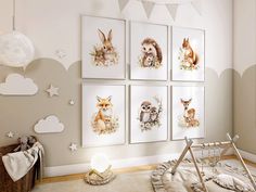 a baby's room with four pictures on the wall and an animal themed crib