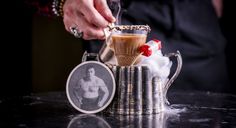 a person is pouring liquid into a cup on top of a table with other items