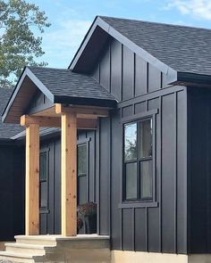 a black house with wooden pillars and windows