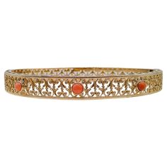 This 14k gold coral bangle is a contemporary piece. Three stunning coral stones take center stage, each delicately cradled in the warm embrace of 14k gold. Their gentle hues bring to mind the soft caress of the sea breeze and the sun's gentle kiss. The coral stones are framed by extensive filigree and milgrain accents that dance like linen in the summer breeze. Like delicate tendrils of dreams, the filigree wraps the entire bangle, creating an enchanting play of light and shadow that dances with your every movement. Each stroke of filigree is a testament to our artisans' dedication to crafting wearable art. Whether you're dressing up for a special occasion or simply looking to infuse everyday life with a touch of magic, our Contemporary Coral Bangle is the perfect companion. This bangle me Coral Bangles Gold, Coral Bangles, Coral Bracelet, Dance With You, Coral Stone, Sea Breeze, Summer Breeze, Gold Jewellery Design, Jewellery Design