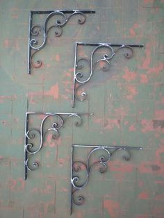 three metal shelf brackets on a wall