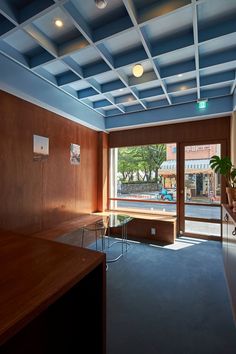 an empty room with wood paneling and glass doors that lead to a parking lot