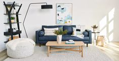 a living room with blue couches and white rugs on the hardwood flooring