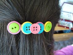 a close up of a child's hair with buttons in the shape of three circles