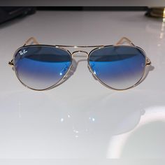 Ray-Ban Original Aviator Sunglasses. New Perfect Condition. Same Day Shipping. Golden Metal Frames. Gradient Lenses. Includes Case, Flannel Open Bridge Detail. Silicone Nosepieces For Optimum Fit. 100% Uva/Uvb Protection. Made In Italy. Modern Blue Aviator Sunglasses With Gradient Lenses, Blue Anti-reflective Aviator Sunglasses, Blue Aviator Sunglasses With Mirrored Lenses, Blue Aviator Sunglasses With Tinted Lenses, Blue Gradient Aviator Sunglasses With Glass Lenses, Blue Gradient Aviator Sunglasses, Modern Blue Glass Aviator Sunglasses, Blue Tinted Aviator Sunglasses, Casual Blue Aviator Sunglasses