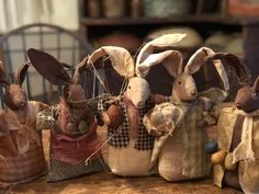 several stuffed rabbits sitting on top of a wooden table