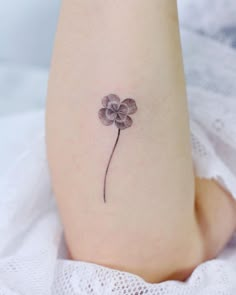 a small four leaf clover tattoo on the ankle, with three petals attached to it