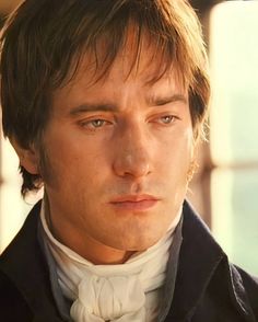 a close up of a person wearing a suit and tie with his eyes wide open